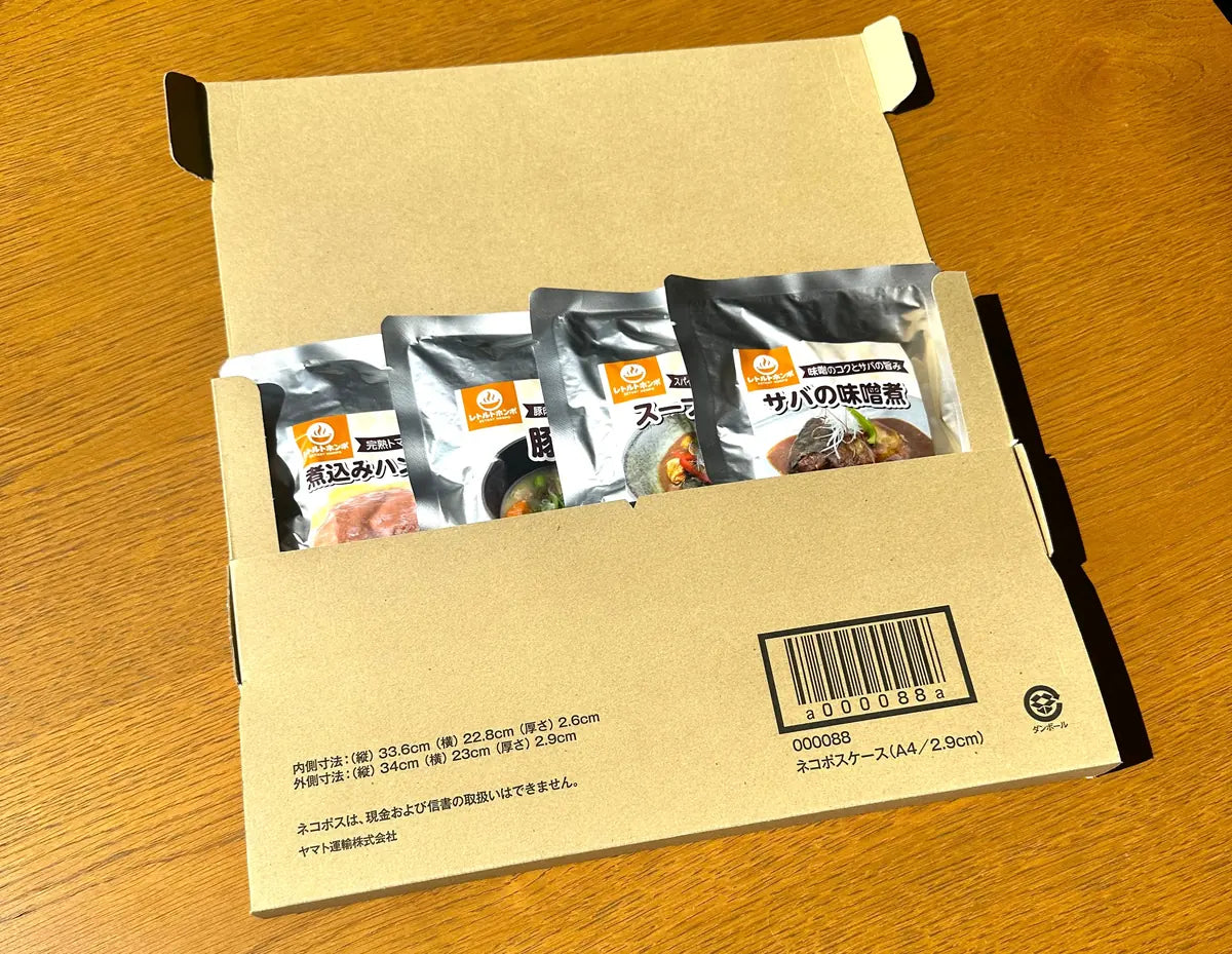 4食セットの梱包。ヤマトのネコポスケースに煮込みハンバーグ・豚汁・スープカレー・サバの味噌煮の4パウチが入っている