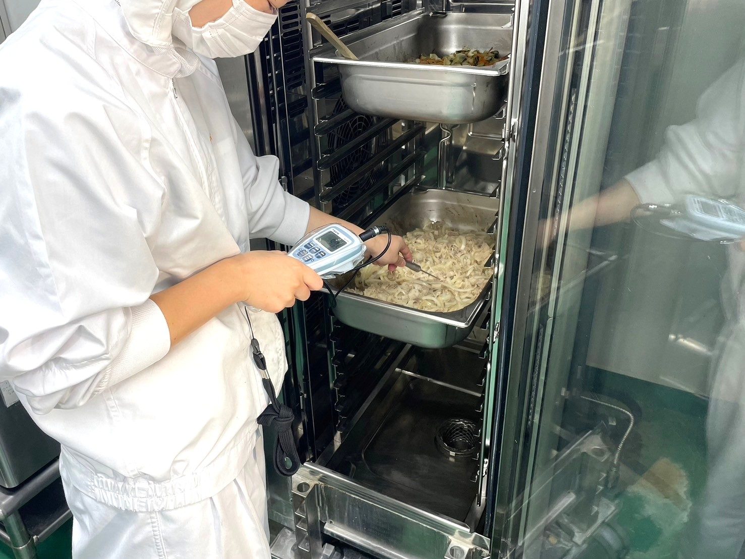 セントラルキッチンで加熱した食材の中心温度を測定している様子