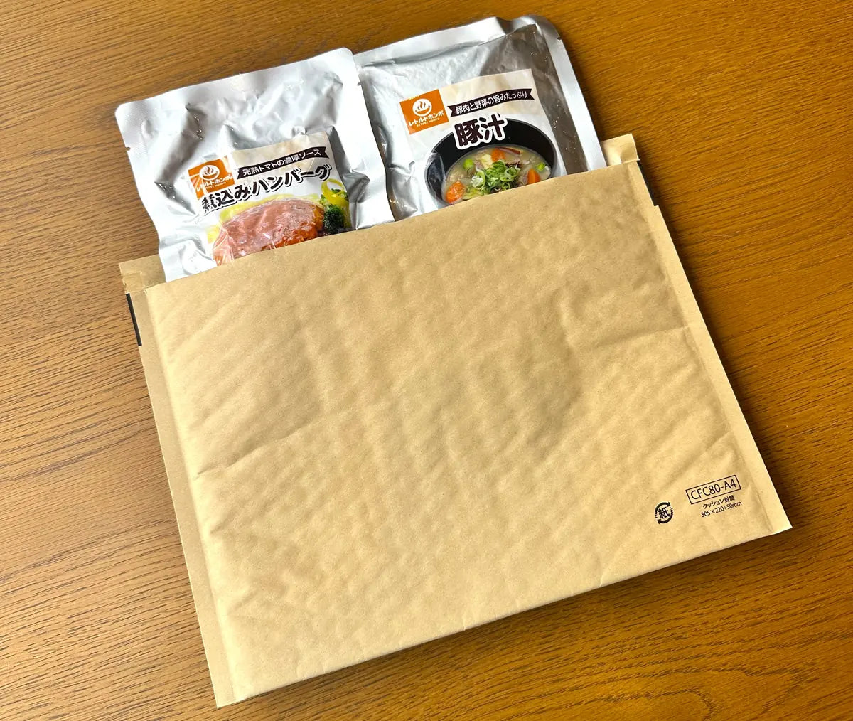 2食お試しセットの梱包。ネコポスのクッション封筒に、煮込みハンバーグと豚汁の2パウチが入っている